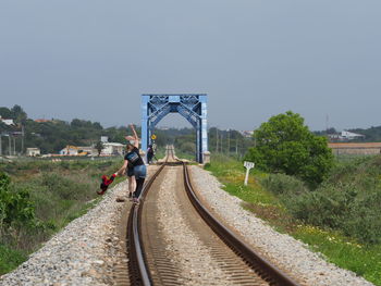 Railroad track amidst trees against sky