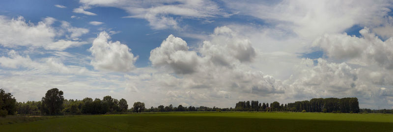 Scenic view of grassy field against cloudy sky