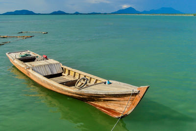 Boat moored in sea against sky