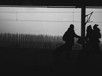 Silhouette people on field against sky