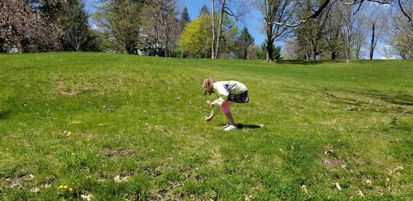 Girl picking flower in field