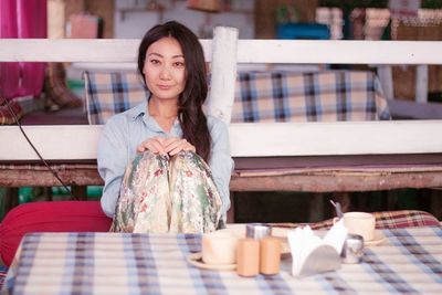 Portrait of smiling young woman sitting at cafe