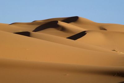 Sand dune in desert against clear sky