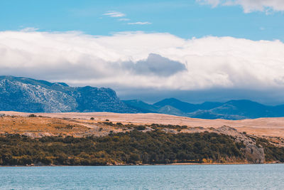 Scenic view of lake by mountains against sky