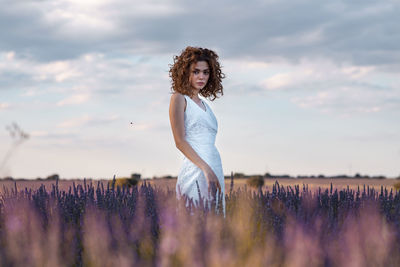 Woman standing on field against sky