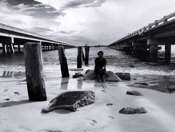 Rear view of man with reflection in water against sky