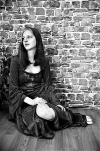 Young woman sitting on hardwood floor