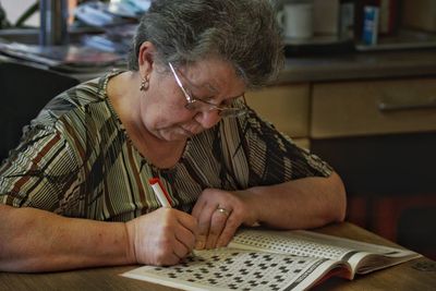 Woman writing on book at home