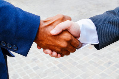 Close-up of men doing handshake outdoors