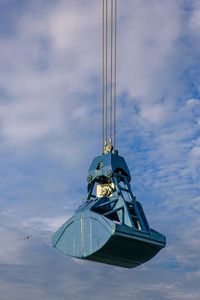 Low angle view of crane against sky