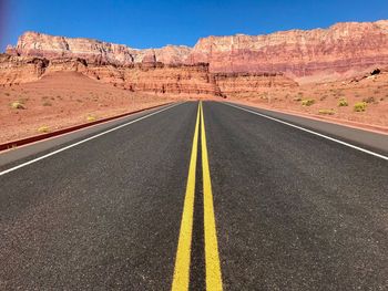 Road leading towards mountain against sky, vermilion cliffs