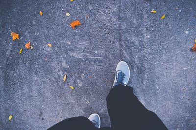 Low section of man with umbrella on street