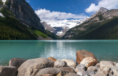 Scenic view of lake by mountains against sky