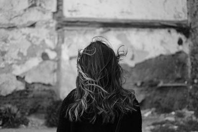 Portrait of woman standing against wall