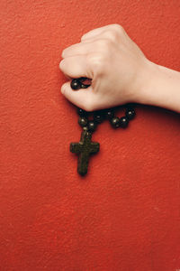 Close-up of woman hand on red wall