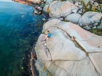 High angle view of man on rock by sea