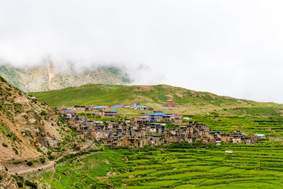 Scenic view of village by building against sky