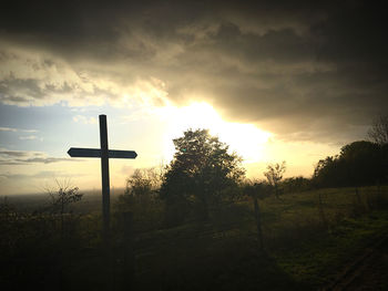 Silhouette cross against sky during sunset