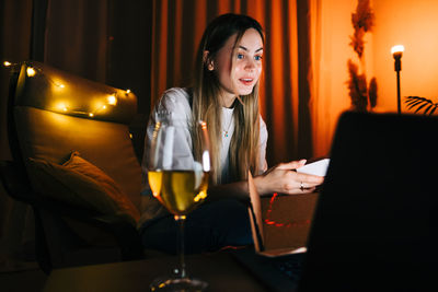 Young woman using mobile phone at home