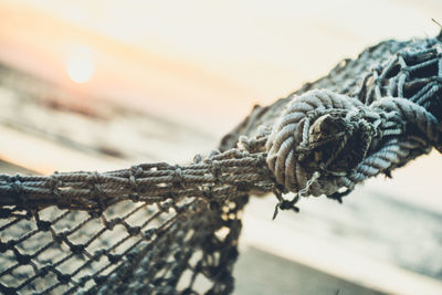 Close-up of hammock at beach against sky during sunset