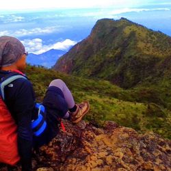 Rear view of man relaxing on mountain