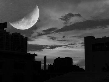 Low angle view of silhouette buildings against sky at night