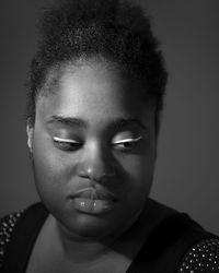 Close-up of young woman with eyeshadow against gray background