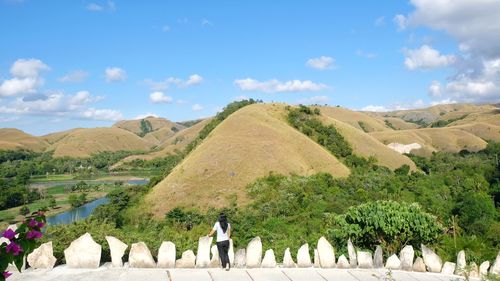 Rear view of woman standing against mountains