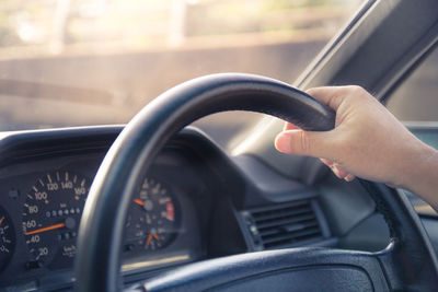 Cropped image of hand holding glass of car