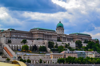 Low angle view of hungarian national gallery at buda castle against cloudy sky