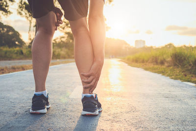 Low section of women walking on road