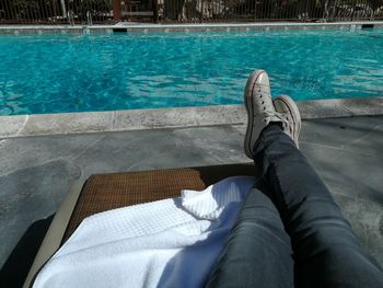 Low section of man relaxing in swimming pool