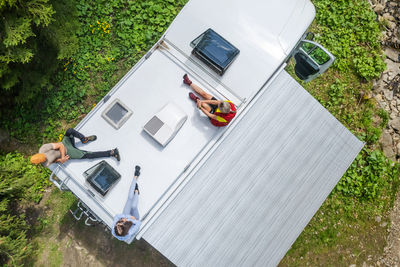 Aerial view of friends sitting on camper van