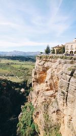 View of plants growing on landscape against cloudy sky