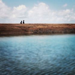 Scenic view of river against cloudy sky