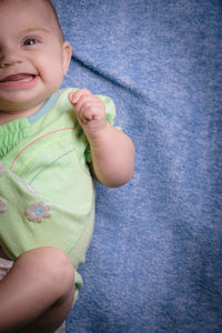 Smiling cute baby girl lying on bed at home