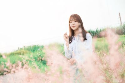 Smiling young woman standing on field