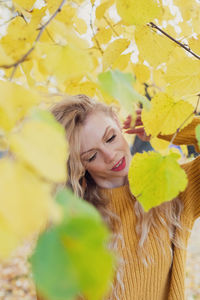 Portrait of young woman with yellow leaves