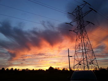 Silhouette of electricity pylon at sunset