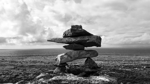 Stack of rocks at beach against sky