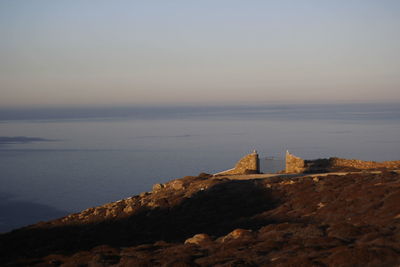 Scenic view of the sea and a wall with a metal gate against the sky