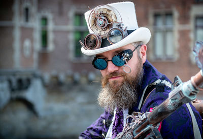 Portrait of mature man wearing costume sitting against building