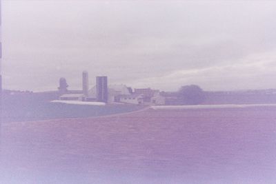 View of cityscape against cloudy sky
