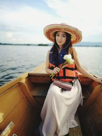 Woman sitting on boat in sea against sky