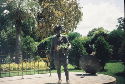 Man standing by plants against trees