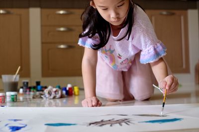High angle view of girl painting on floor 