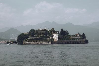 Built structure on sea against buildings in city