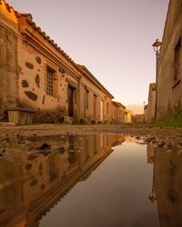 Reflection of buildings in lake at sunset