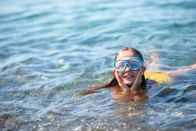 Portrait of smiling woman swimming in sea