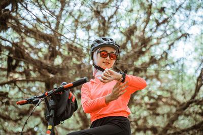 Low angle view of woman checking time at park